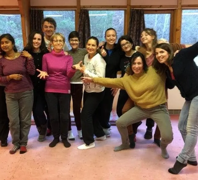Un groupe de stagiaires rit et prend la pose dans une salle de stage