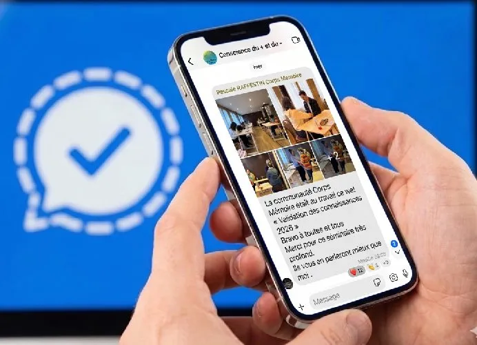 Un smartphone tenu à deux mains affiche la conversation du groupe d’échanges Corps Mémoire : photos d’un week-end de « Validation des connaissances 2026 » et messages des stagiaires