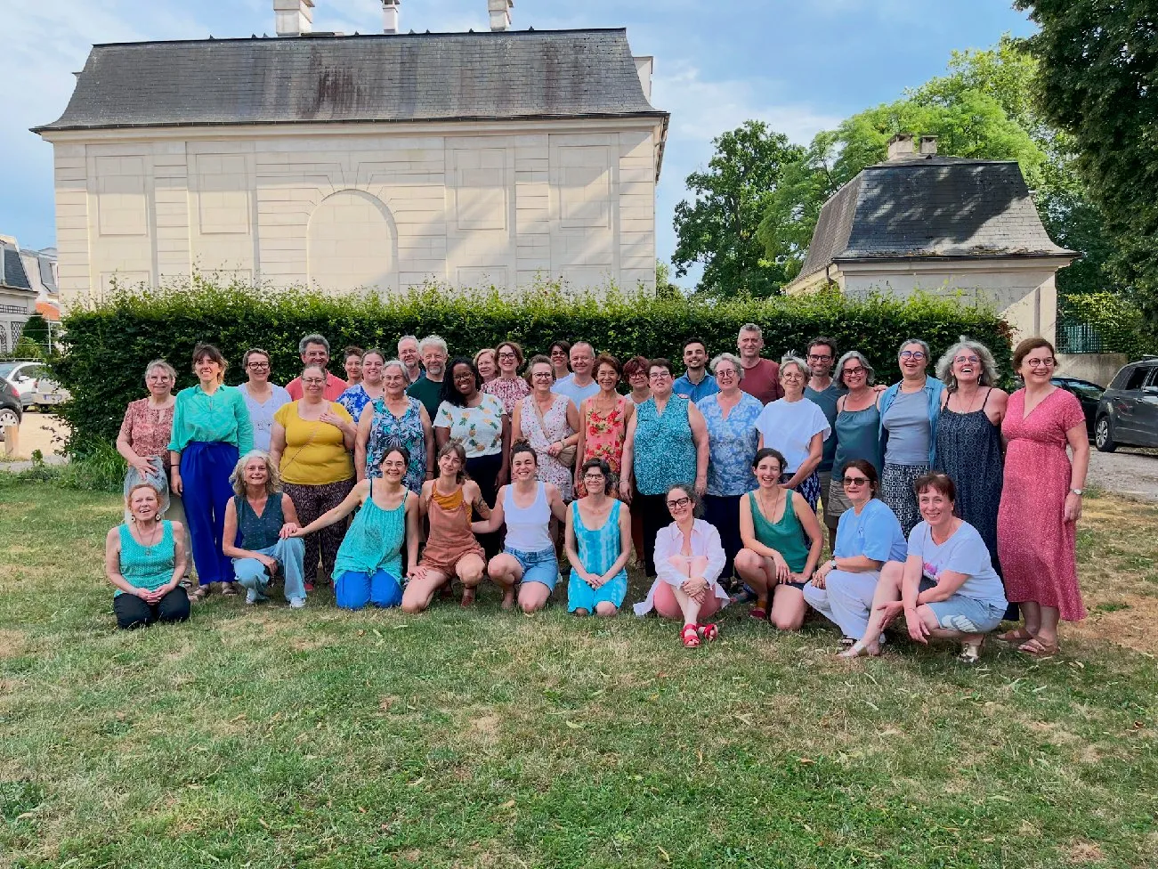 Photo de groupe des participants d’un stage, dans un parc devant une maison de maître