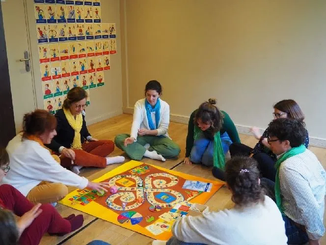 Partie du jeu « Rallye Pleine Forme » : des adultes et un enfant assis par terre autour du plateau de jeu
