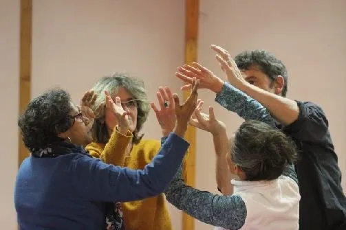 Des stagiaires lèvent les bras et joignent leurs mains au cours d’un exercice de groupe.